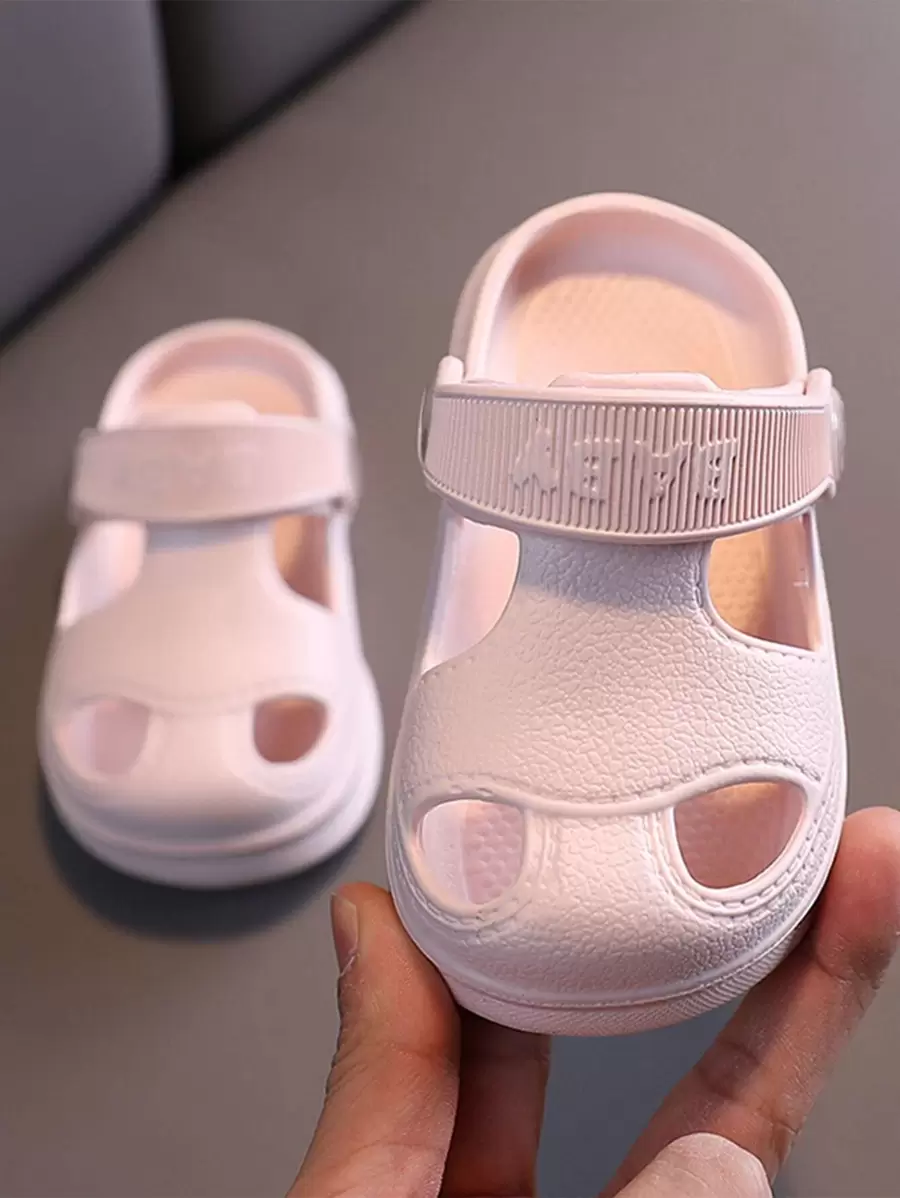 Un par de sandalias de playa minimalistas, de suela blanda y huecas, para niñas pequeñas