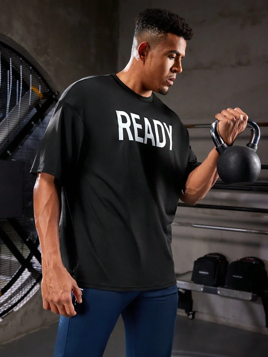Manfinity Sport Corelite Camiseta deportiva de manga corta con estampado de letras estilo novio para hombre