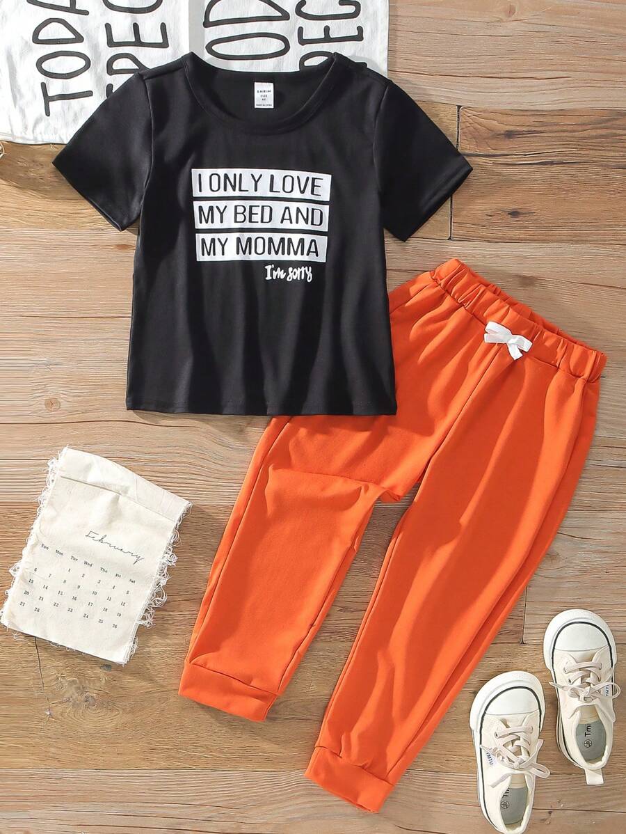 SHEIN CHŁOPIEC Casual Sports College Street Style Uroczy wakacyjny czarny nadruk z literami T-shirt z krótkim rękawem i pomarańczowe spodnie Nadaje się do noszenia na co dzień, do szkoły, podróży, sportu, wiosny i lata