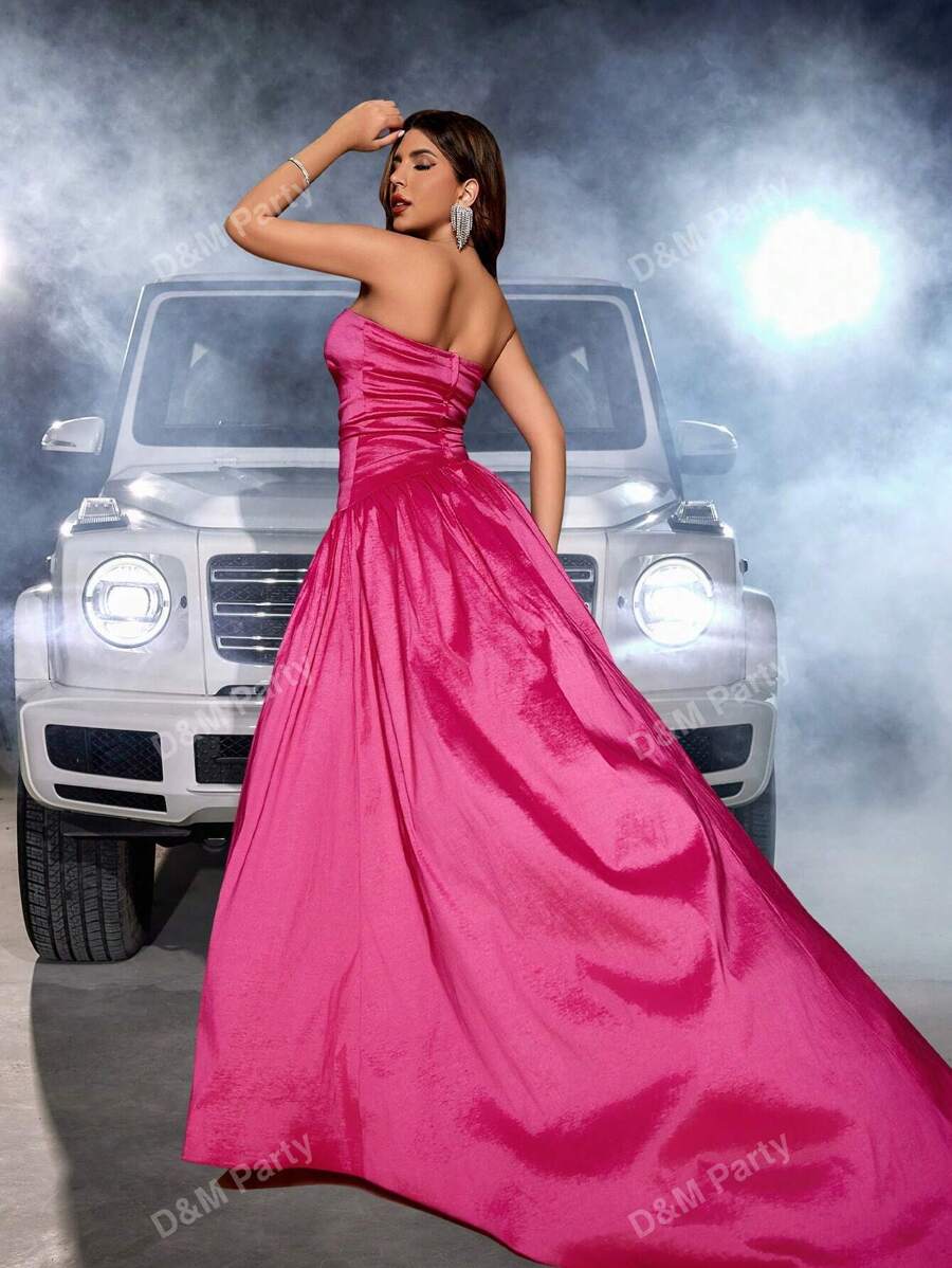 A Strapless Prom Gown With A Straight Neckline, A-Line Silhouette, Asymmetrical Dropped Waist, Open Back, Thigh High Front Slit, And A Train