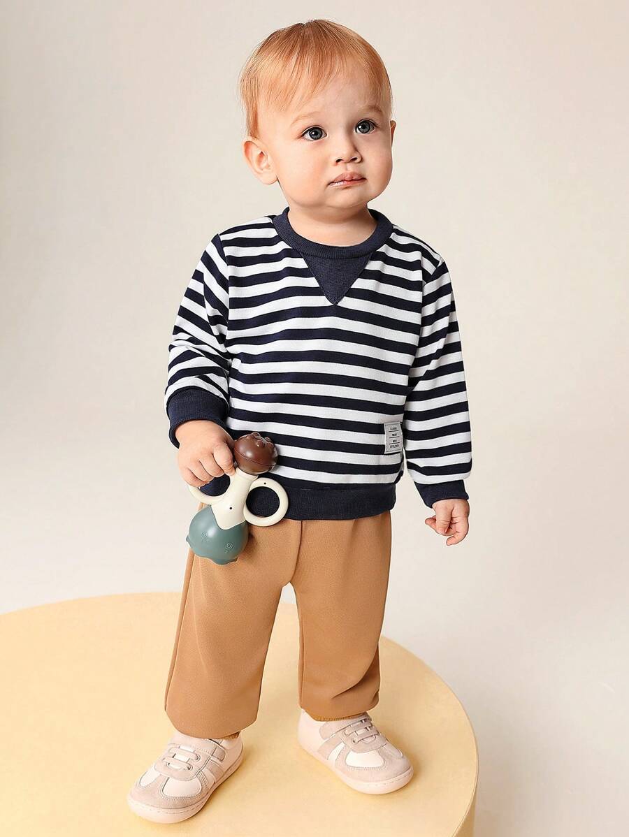 SHEIN 2 Stücke Set aus langärmligem, gestreiftem Rundhalsshirt und bundfreien, einfarbigen langen Hosen für Babys, warm und bequem für Babys im Herbst und Frühling. Dieses Set eignet sich sowohl für den Alltag als auch für zu Hause. Dieses vielseitige Set eignet sich für den Alltag von Babys zu verschiedenen Anlässen und sorgt dafür, dass sie sich in den Übergangsjahreszeiten wohlfühlen.