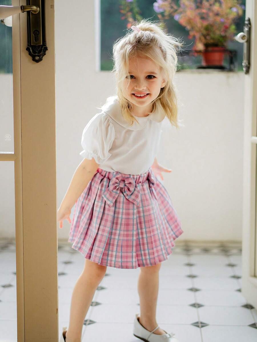 SHEIN Conjunto de blusa de manga corta con cuello Peter Pan y abertura trasera + falda mini con volantes y decoración de lazo para niñas, dulce y lindo