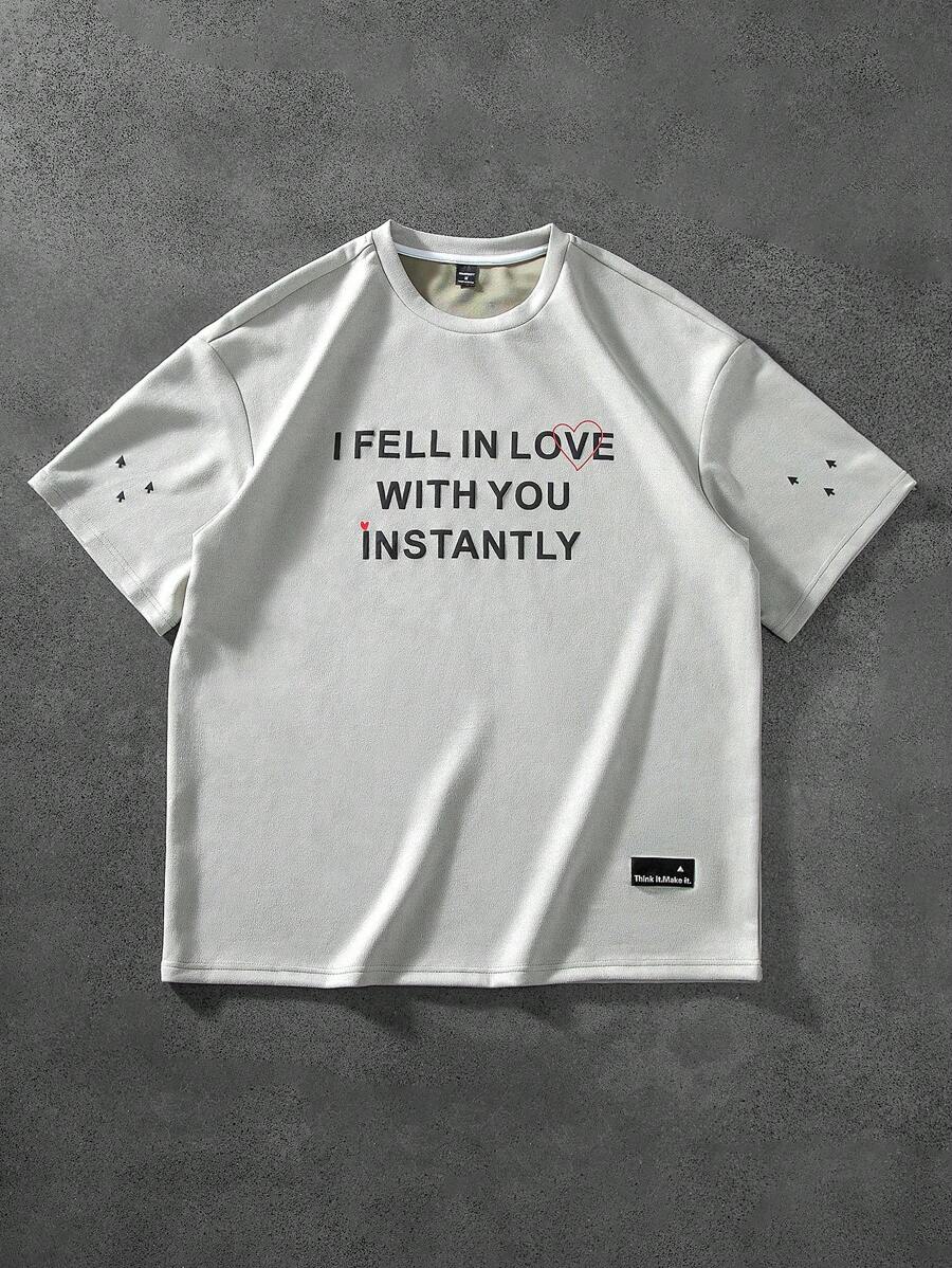 Manfinity Hypemode "Men's Casual Daily Style, Spring Vacation Look, INS Matching Item: Unique Niche Suede Fabric Short-Sleeve T-Shirt In Light Gray-Green With A 3D Foam Printed Design On The Front, Featuring A Heart And The Valentine's Day Slogan 'I FEEL IN LOVE WITH YOU INSTANTLY.' This T-Shirt Is Perfect For Spring And Summer Outfits And Ideal For Matching Couple Styles, Making It A Great Gift For Boyfriends Or Husbands."