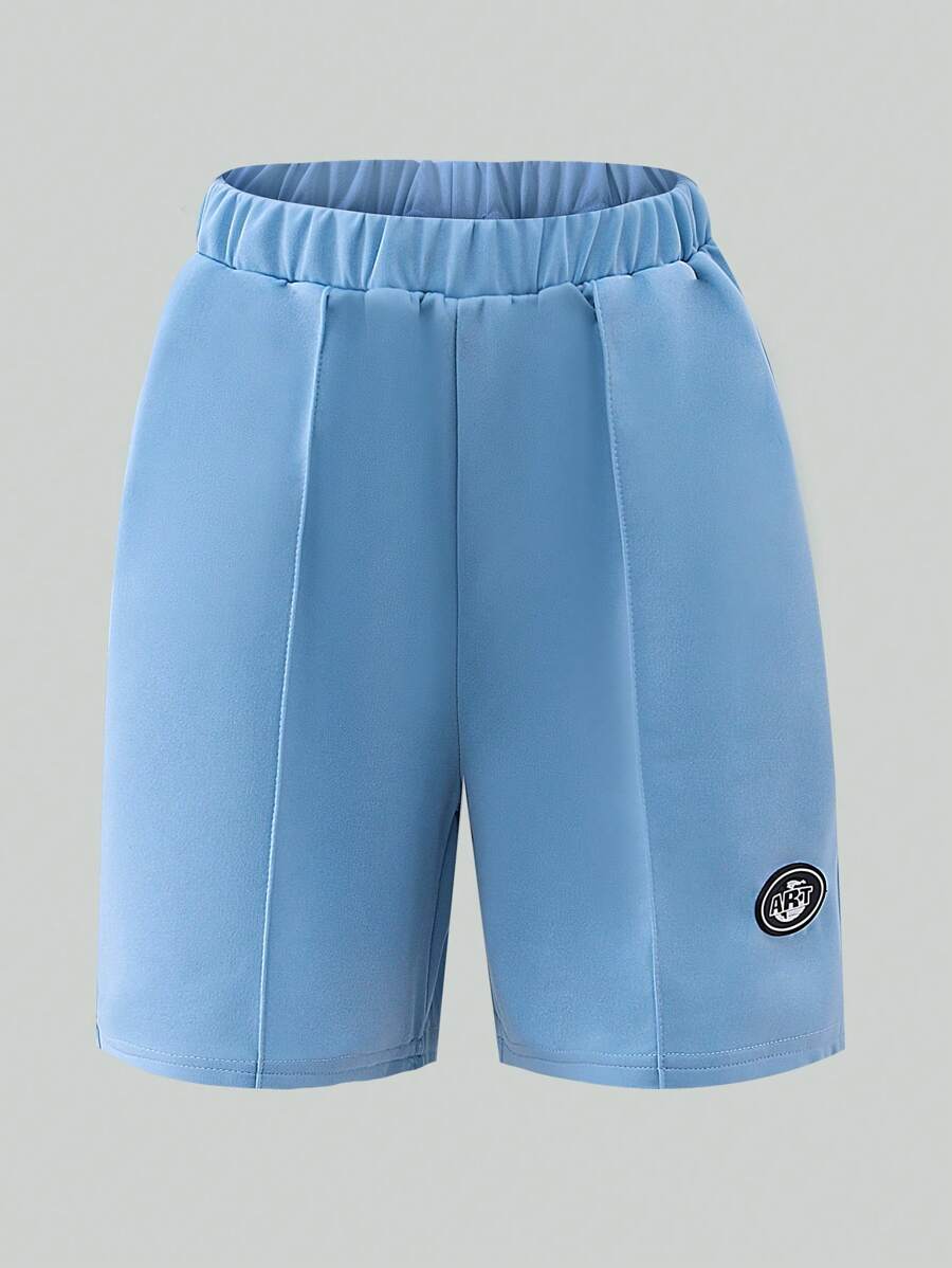 SHEIN 1 Pc Boys Casual Plain Loose Shorts, Featuring Minimalist Design With Patch At Hem. These Lightweight Blue Shorts Are Perfect For Summer Leisurewear, Suitable For Various Skin Tones And Occasions. The Simple Yet Elegant Design Prioritizes Comfort.