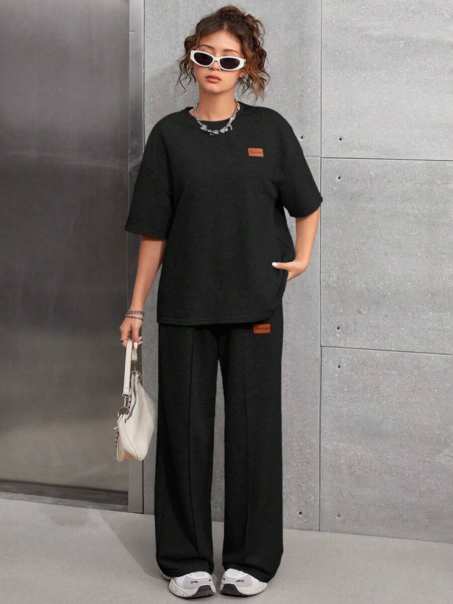 SHEIN Set casual da 2 pezzi per ragazze adolescenti - Maglia nera a maniche raglan, girocollo, con applicazione, spalle scoperte e pantaloncini sportivi