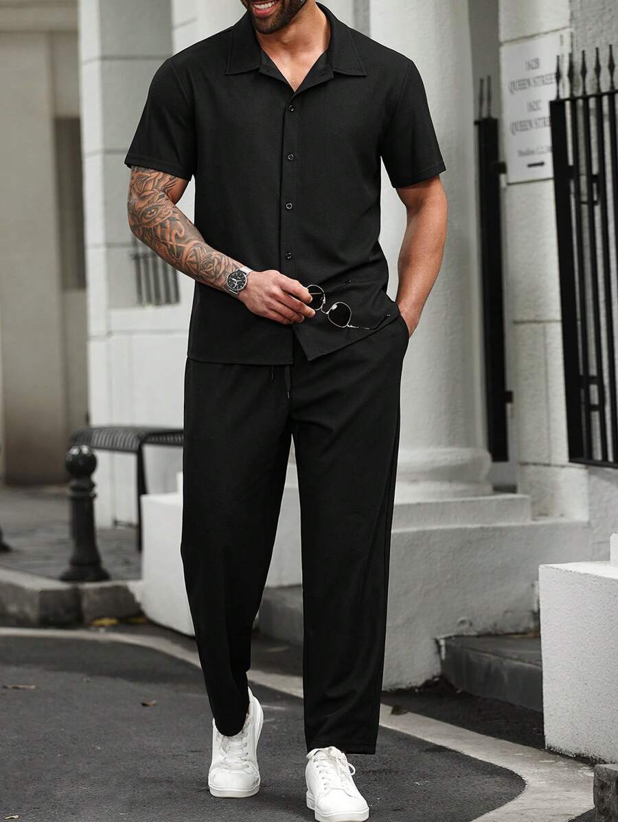 Manfinity CasualCool Conjunto casual de uso diario para hombres de talla grande: Estilo de vacaciones en la playa, conjunto a juego de camisa negra INS con textura de tejido de gofre jacquard. Presenta un conjunto de camisa de manga corta y pantalón largo con diseño de botones. Perfecto para atuendos refrescantes de primavera y verano, adecuado para vacaciones en la playa de Hawái, y un gran conjunto para parejas en el Día de San Valentín, lo que lo convierte en un regalo ideal para novios u hombres 2 piezas Conjuntos de diseñador masculino