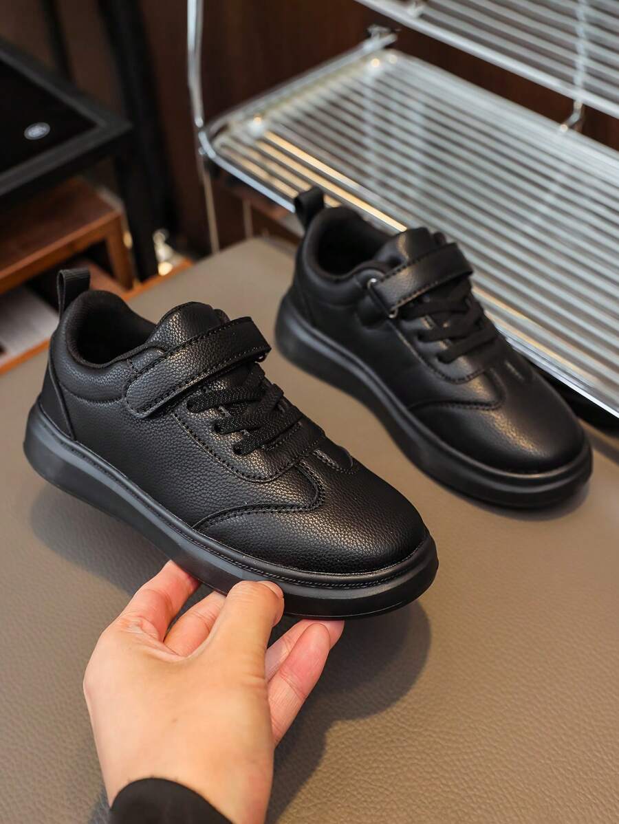 Un par de zapatos nuevos para niños, zapatos negros para niños, cómodos zapatos deportivos para niñas con suelas antideslizantes, zapatos blancos para estudiantes, zapatos para niños con cierre de gancho y bucle, zapatos escolares de PU negro para niños, zapatos escolares blancos cómodos para niños y zapatos de festivales para niños.