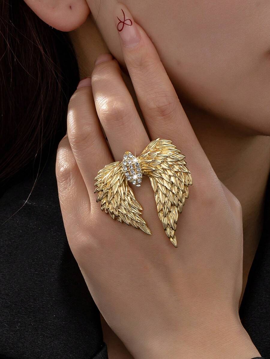 Un anillo abierto con diseño de alas doradas y pedrería de estilo europeo y americano, versátil y con personalidad