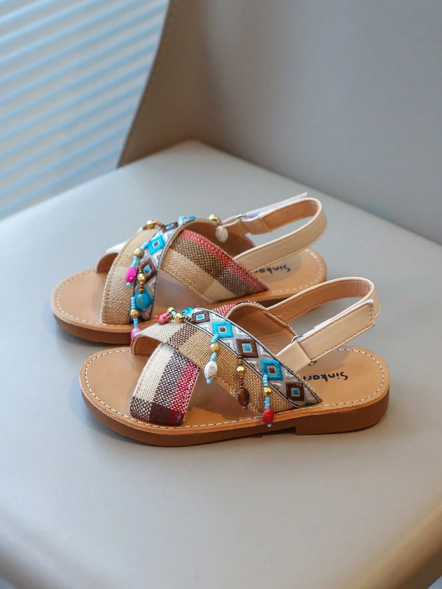 Nouvelles sandales pour enfants en bas doux de style national à la mode avec pendentif croix et pompon, que peuvent porter des amis ou des membres de la famille pour les vacances, les loisirs ou des activités en plein air.