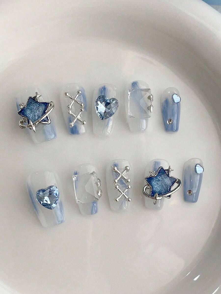 10 pièces de pointes d'ongles en forme de cercueil courtes, faites main, exquises. Design d'art des ongles inspiré de l'océan avec teinture bleue nouée, orné de pentagones métalliques 3D et de strass en forme de cœur. Convient pour les fêtes, les mariages et l'usage quotidien. Comprend 1 pièce de gel de gelée et 1 pièce de tampon à ongles. Ongles à clipser.