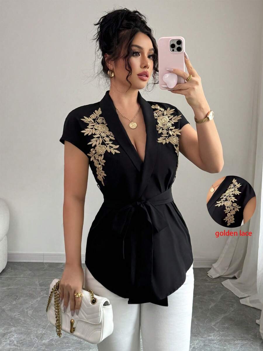 Calvaya Elegante e versatile blusa nera da donna a maniche corte con arricciatura frontale, retro lungo, con rifinizione in pizzo dorato e tessuto non elastico