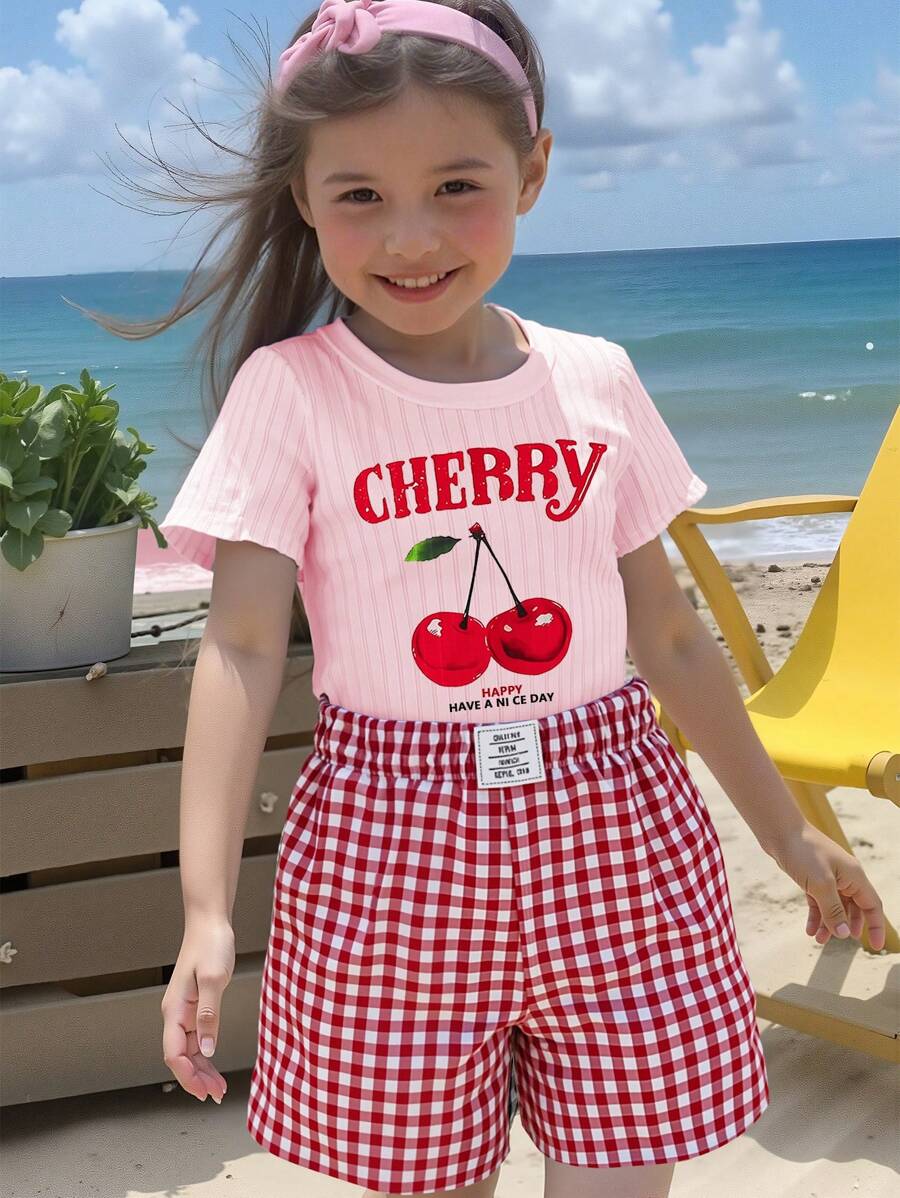 SHEIN Conjunto de 2 piezas para verano: Camiseta de punto de manga corta con cuello redondo y estampado de cerezas + pantalones cortos rojos a cuadros holgados para niñas