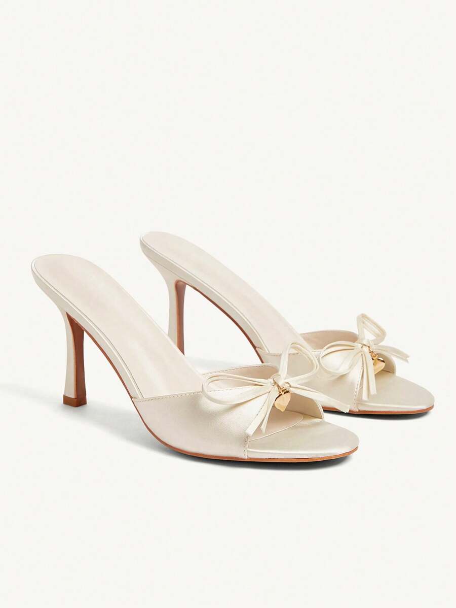 CUCCOO CHICEST Beige sandalen voor dames met gouden metalen hart- en strikaccent, elegante muiltjes met ronde neus en hoge hak
