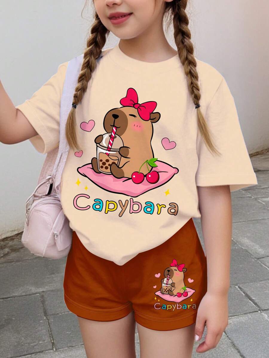 2 pièces Set hauts à manches courtes et shorts d'été imprimés capybara mignon et nœud de cerise, tenue d'été décontractée pour jeunes filles, convient pour les sorties d'été et la mode plage