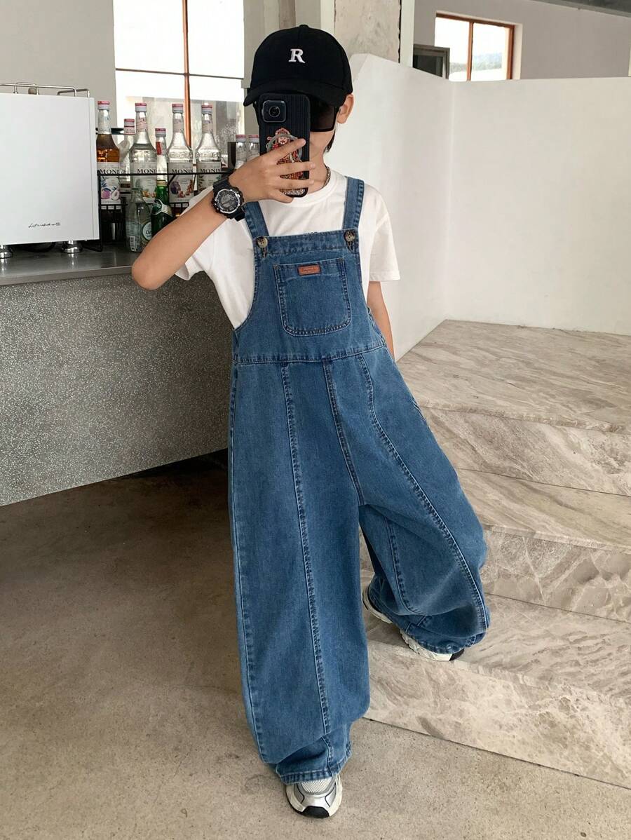 Tute di jeans blu oversize per ragazzi di età preadolescenziale con dettagli di etichette e spacchi in stile vintage cool Y2K, adatte per costumi, abbigliamento quotidiano, uscite estive e autunnali, festival, spiaggia, streetwear, abbigliamento scolastico