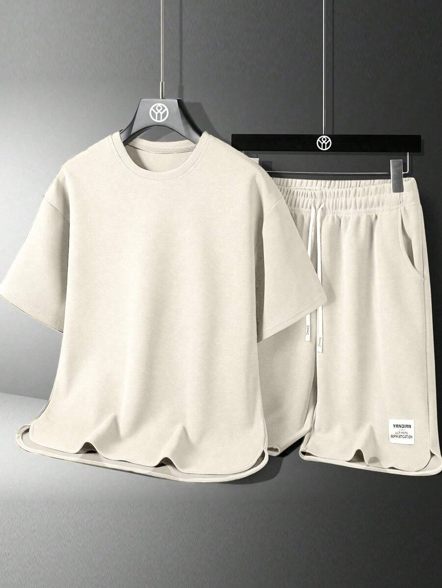 Conjunto de camiseta casual de manga corta de cuello redondo y unicolor, y shorts con estampado de letras y cordón en la cintura para hombres en verano