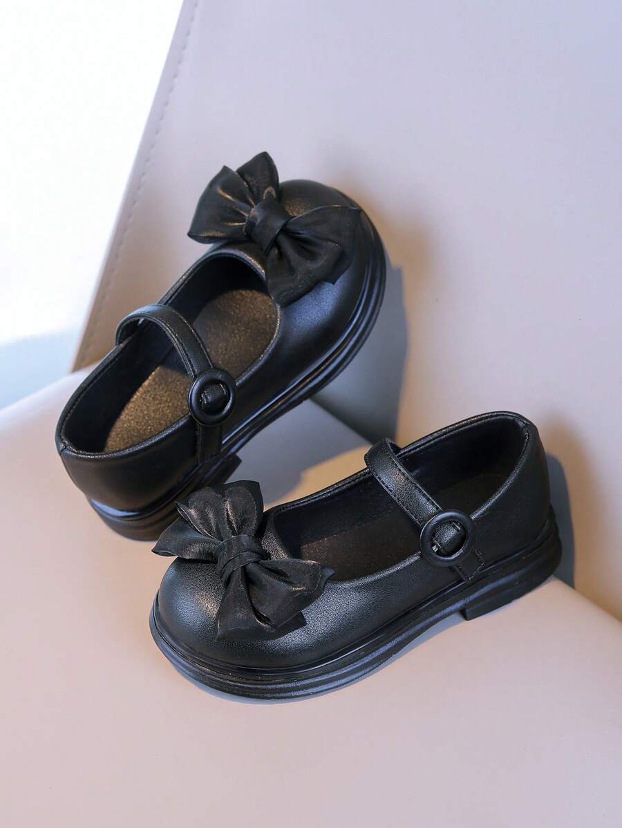 Zapatos elegantes negros para niñas: El lacito añade un Charm femenino