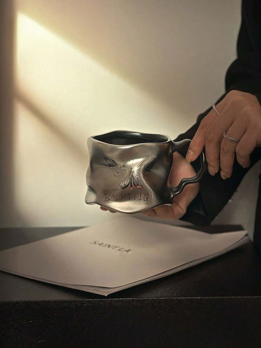 This Dark Butterfly Style Cup Has A Unique Design. With A Dark Tone, The Cup Body Features A Butterfly Relief, Embodying The Aesthetic Of Dark Beauty. The Material May Be Ceramic, Processed To Have A Metallic Luster. The Asymmetrical Cup Body Is Paired With A Curved Handle, Balancing Artistic Appeal And Comfortable Grip. Can Be Used As A Daily Drinkware Or Home Decor. Back To School