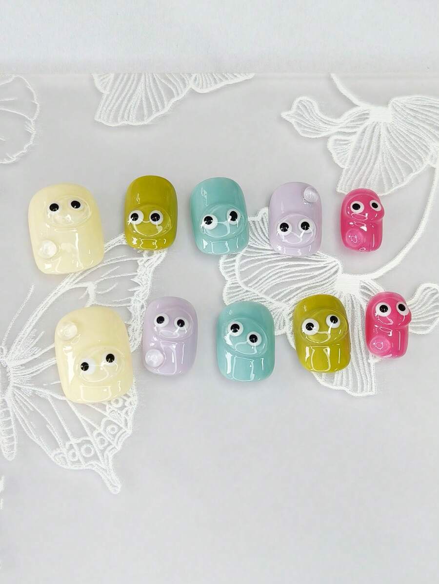 1 set de 10 ongles courts carrés exquis avec un motif peint à la main "Y2K candy dopamine" en trois dimensions et en couleurs transparentes avec de mignons petits yeux, dans un style minimaliste. Ces accessoires pour ongles allongent l'apparence des doigts et apportent une touche .