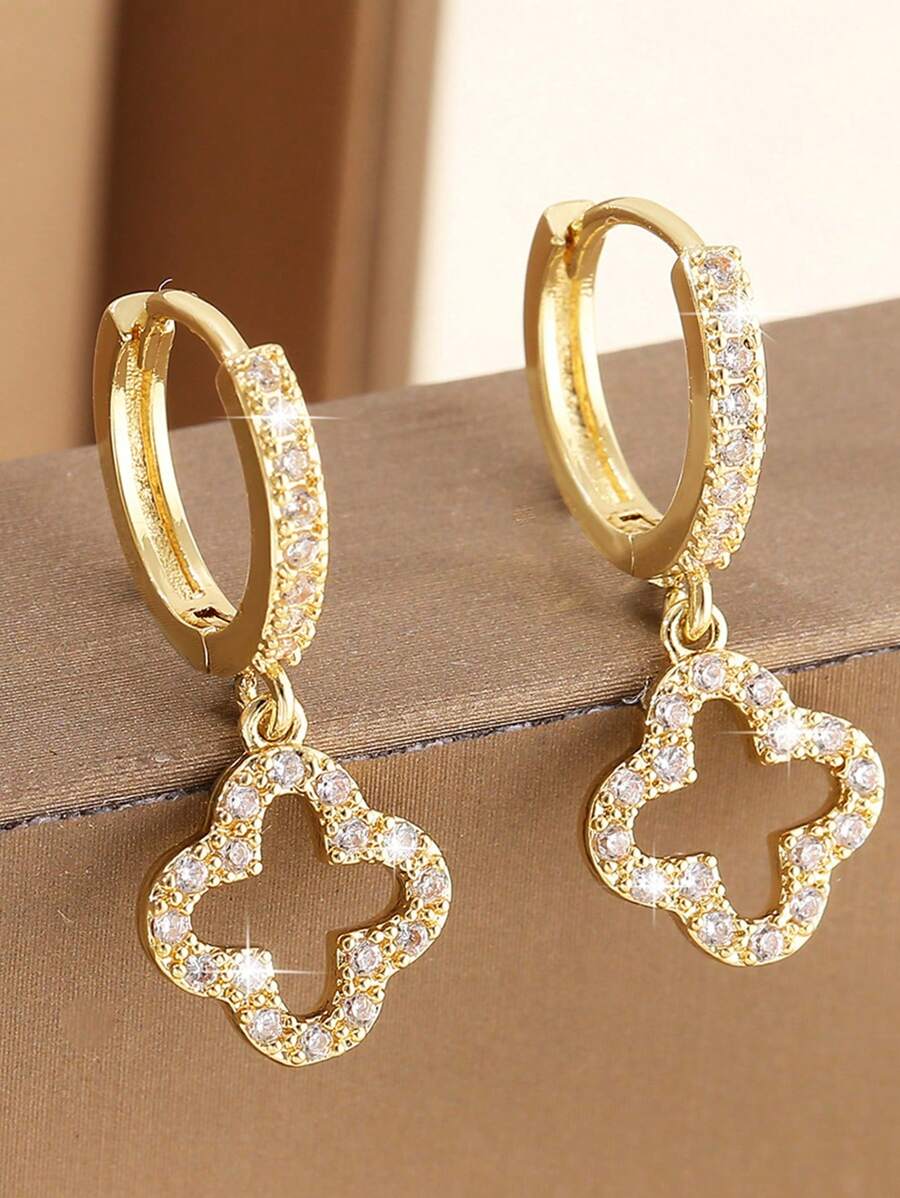 Un par de pendientes de cobre lujosos con circonita, con un diseño floral estelar hueco simple y elegante