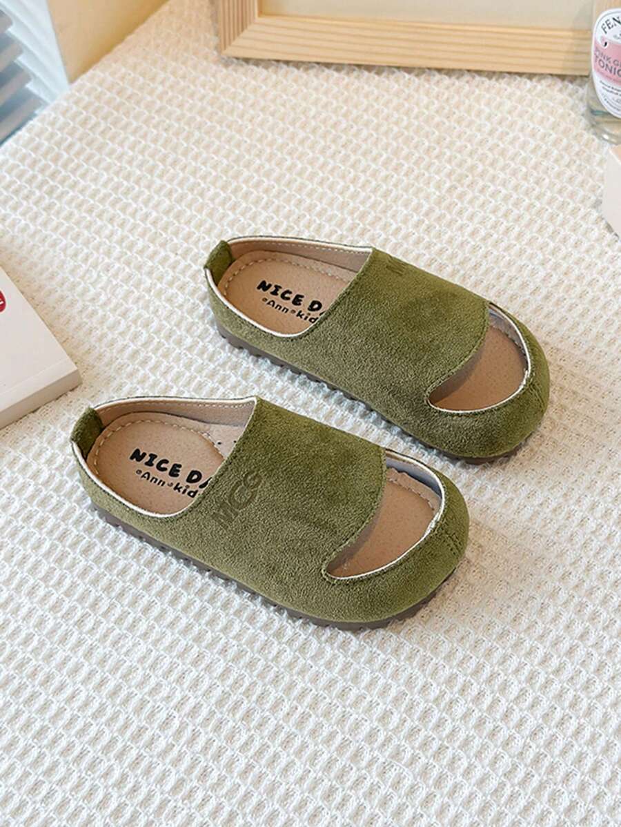 Este es un par de chanclas para niños con puntera. El estilo es de una sola pierna y el material de la parte superior parece ser de ante. La suela es gruesa. Este calzado unisex para niños pertenece a la edición coreana minimalista del verano de 2025.