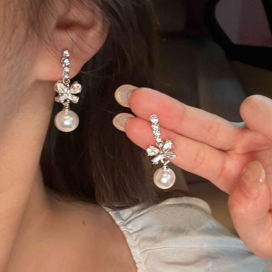 1 paire de boucles d'oreilles élégantes de style boutique avec un nœud papillon et un design de fausse perle. Chic pour les dames, convient pour un port quotidien