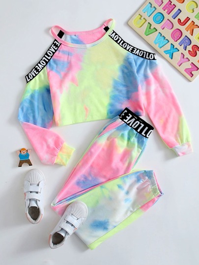 ثنية الفتاة الصغيرة تجمع بين بلوفر يظهر الكتفين وبنطال رياضة تعريشة ملوّن