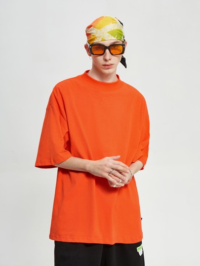 تي شيرت بلون موحد ومنخفض الكتف بلون النيون البرتقالي للرجال