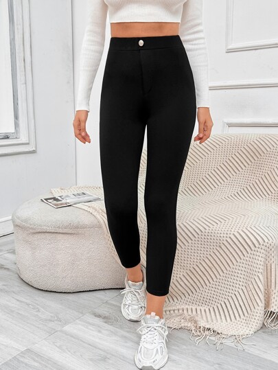 بنطلون أسود ضيق بتفاصيل زر وجيوب معدنية