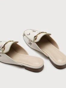 Mules planos con bordado floral con diseño metal