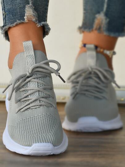 Damskie szare buty do biegania z sznurowaniem z przodu i przewiewną konstrukcją. Pasują do legginsów