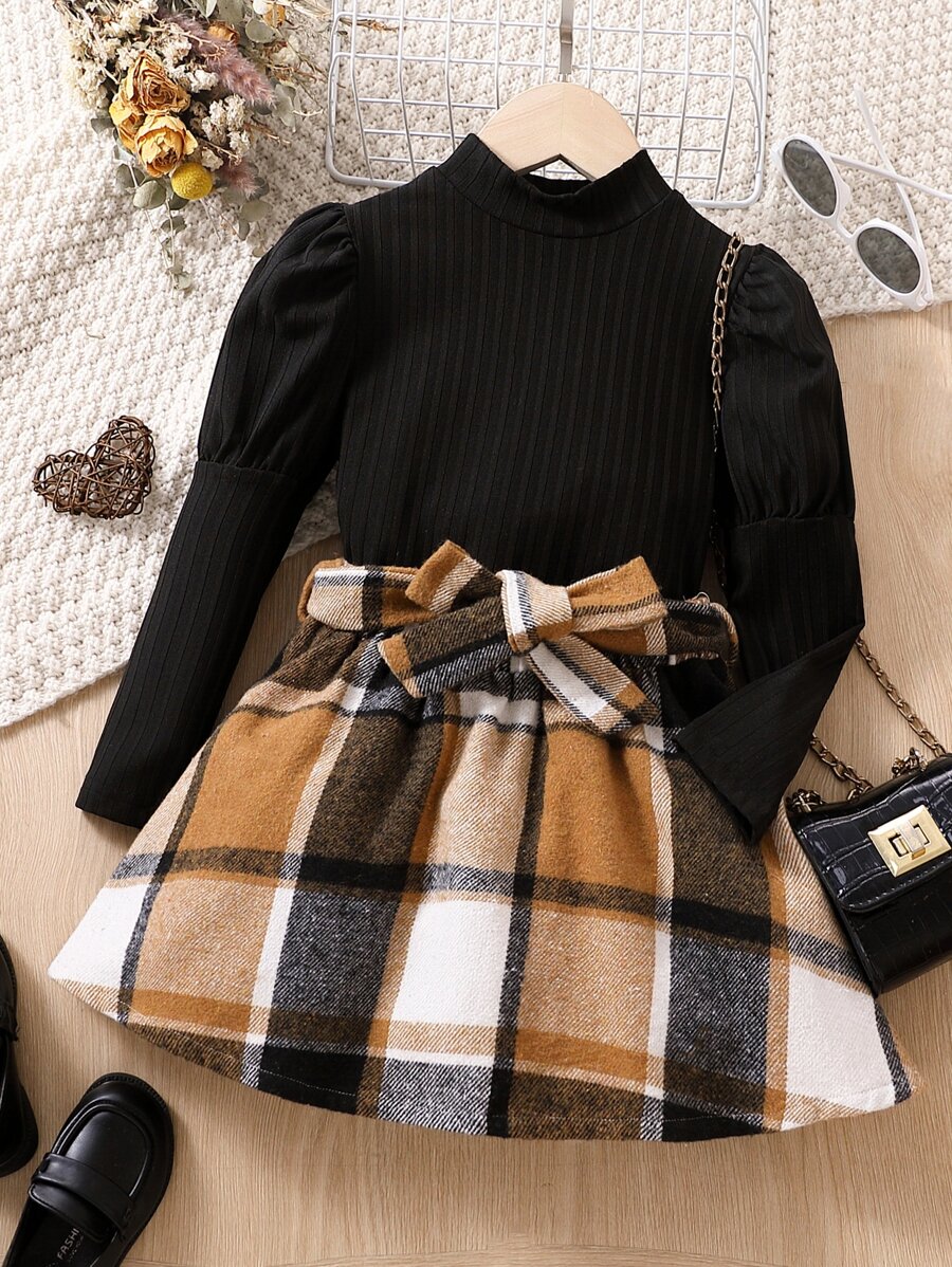 年輕女孩高領落肩袖上衣和格紋腰帶裙