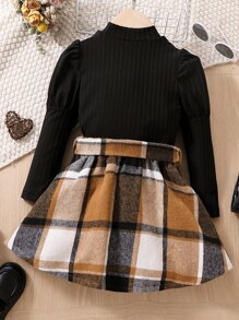 年輕女孩高領落肩袖上衣和格紋腰帶裙