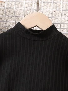 年輕女孩高領落肩袖上衣和格紋腰帶裙