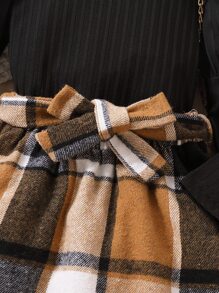 年輕女孩高領落肩袖上衣和格紋腰帶裙