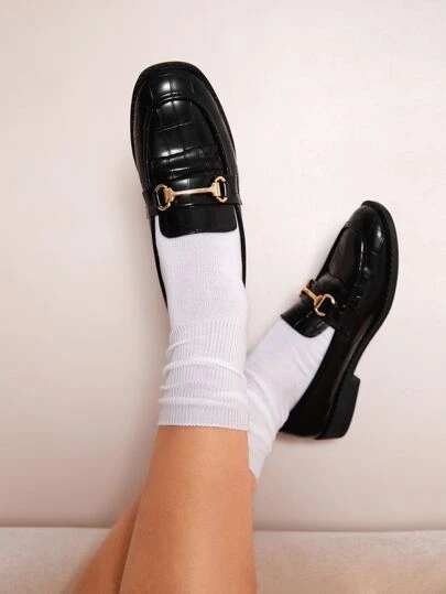 Mocasines planos con cocodrilo en relieve con diseño de hebilla