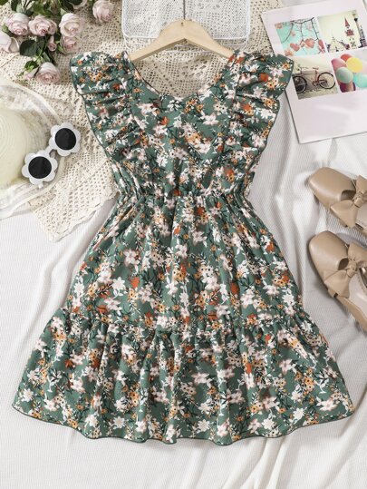 Sparklyn Denna tween-flickklänning med blommönster och volangkant har en elegant och charmig design. Blomtrycket skapar en atmosfär. Volangkanten ger en lekfull och graciös touch. Det lätta och andningsbara tyget är bekvämt för vår- och sommarkläder. Den moderiktiga mönstret och volangdesignen visar upp en elegant smak och utstrålar feminin lockelse. Den övergripande sofistikerade och raffinerade looken passar för olika formella tillfällen. Denna klänning är en snygg höjdpunkt i garderoben och låter bäraren utstråla den graciösa elegansen hos blommande blommor.