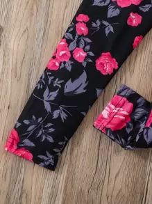 年輕的女孩花卉及字母圖形t恤和緊身褲