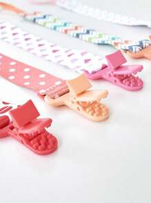 1条齿形双面花卉奶嘴链。颜色随机。带扣环和防缠绕设计，可防止奶嘴、牙胶、玩具丢失、首饰缠绕颈部或掉落造成窒息危险。非常适合新生儿。