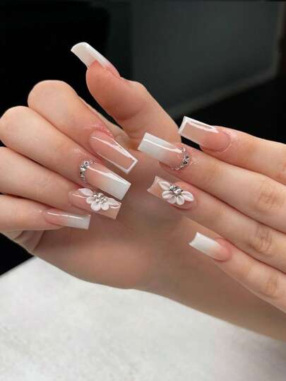 Mejora tu apariencia instantáneamente con 24 uñas postizas en forma de ataúd de longitud media-larga con diseño de flor blanca francesa y acento de rhinestone, estilo europeo; incluye 1 pieza de gel de gelatina y 1 pieza de juego de lima de uñas