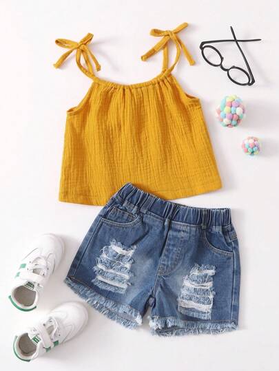 年輕女孩打結肩帶背心和生邊牛仔短褲