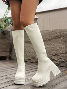 بوت نسائية جديدة لموسم الخريف/الشتاء 2025 من الركبة إلى الفخذ مصنوعة من الأقمشة المحبوكة والمطاطية باللون الأبيض مع كعب سميك وبطانة خفيفة الوزن