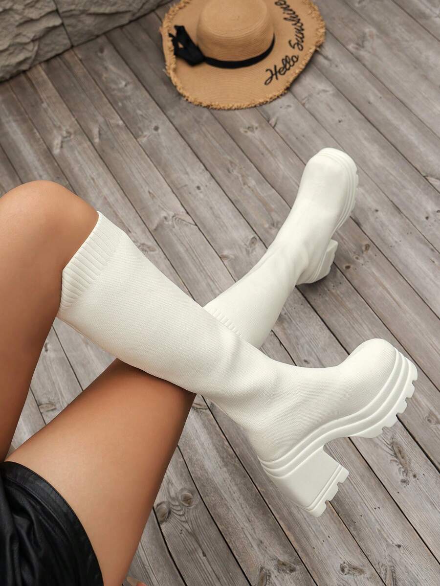 بوت نسائية جديدة لموسم الخريف/الشتاء 2025 من الركبة إلى الفخذ مصنوعة من الأقمشة المحبوكة والمطاطية باللون الأبيض مع كعب سميك وبطانة خفيفة الوزن