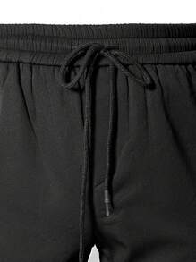 Manfinity Homme Pantalones de carga largos y cónicos para hombre en color negro liso, con recubrimiento térmico en su interior, cintura ajustable con cordón, bolsillo de solapa en el lateral, ideal para salir