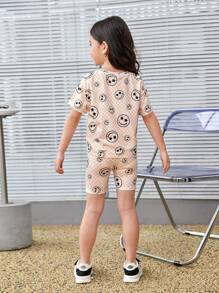 SHEIN Camiseta Casual De Cuello Redondo Y Ajuste Holgado Con Patrón De Rostro Tejido Para Niñas Jóvenes + Conjunto De Pantalones Cortos De Punto