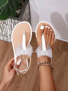 Białe płaskie sandały damskie z połyskującą kokardką ze strasu i kryształkami - eleganckie letnie buty plażowe na świeżym powietrzu