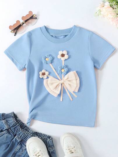 SHEIN Playera de manga corta de verano para niña joven con flor 3D y lazo decorativo en el cuello redondo