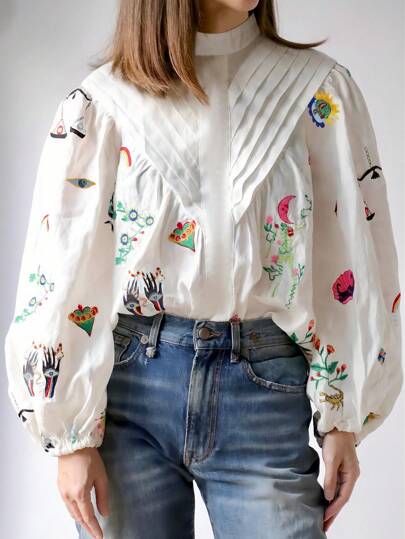 Blusa elegante de mujer con cuello alto y mangas de farol bordada