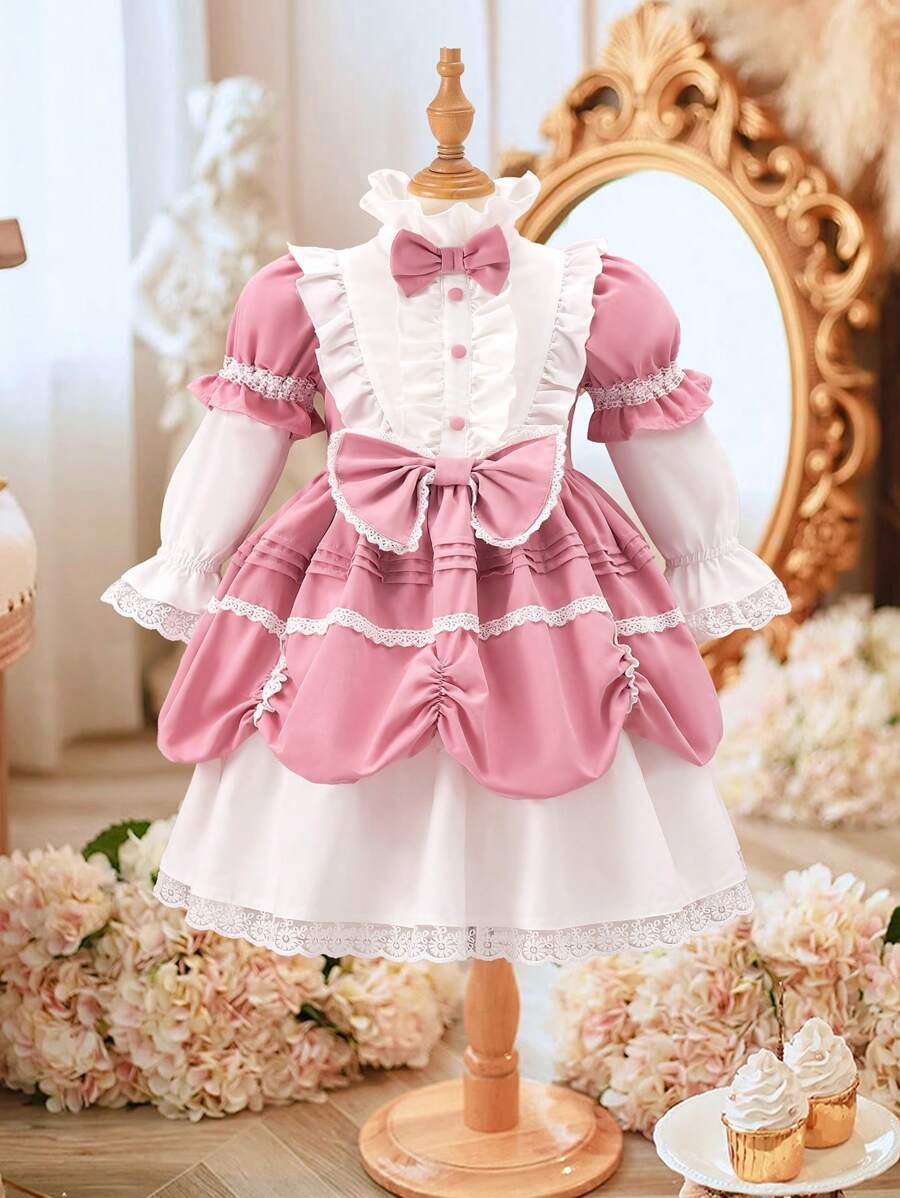 Vestido rosa para niña joven con bloqueo de color blanco, lazos, ribete de encaje y mangas con volantes. El estilo general es suave y dulce, lleno de espíritu juvenil. Los delicados y exquisitos ribetes de encaje decoran el dobladillo y los puños del vestido, agregando una sensación de delicadeza y romance. Adecuado para compras, salidas, fiestas, cumpleaños, bodas o celebraciones en primavera y otoño. - Multicolor - Ver 1