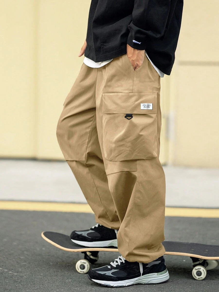 Manfinity EMRG 宽松版型男式抽绳腰工装裤，带字母贴饰和翻盖口袋 - 卡其色 - 查看 1